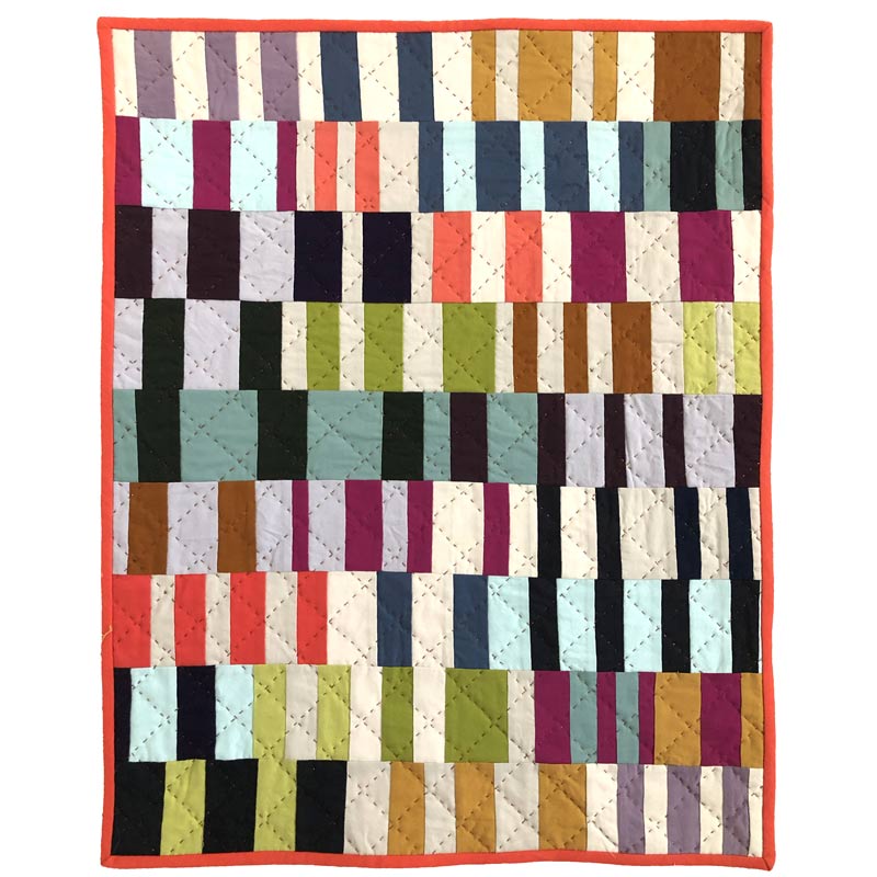 close up of colorful quilt made of rectangles- shows hand quilting