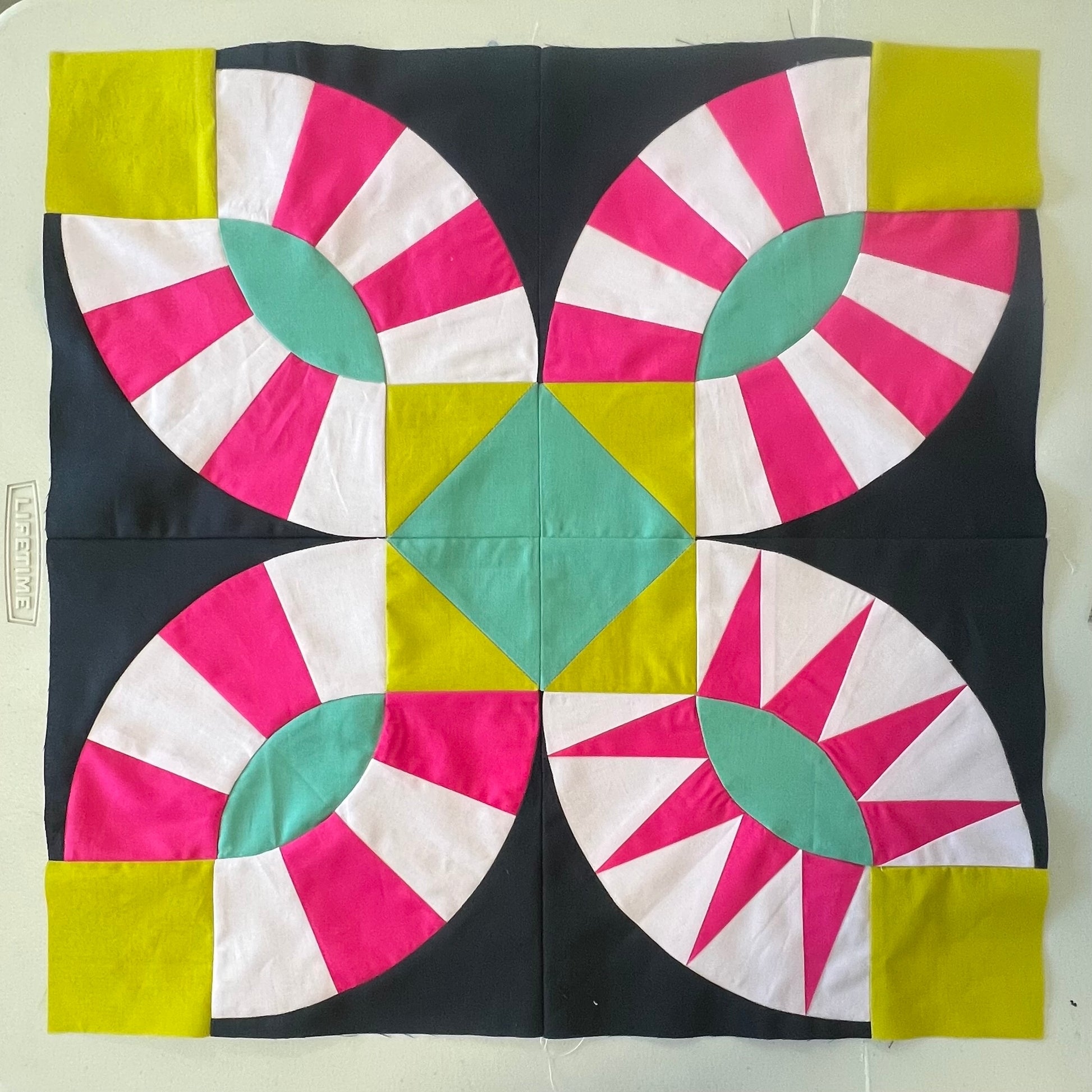 Colorful quilt block with geometric pattern on a white background