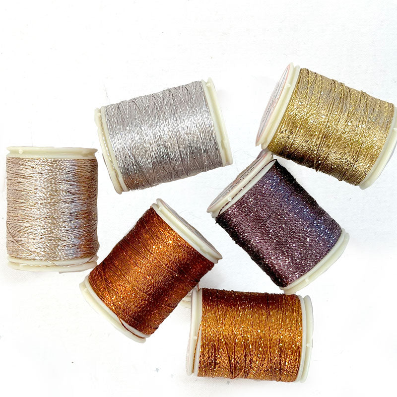 Spools of metallic hand quilting thread in various colors including silver, gold, copper, and sparkling red.