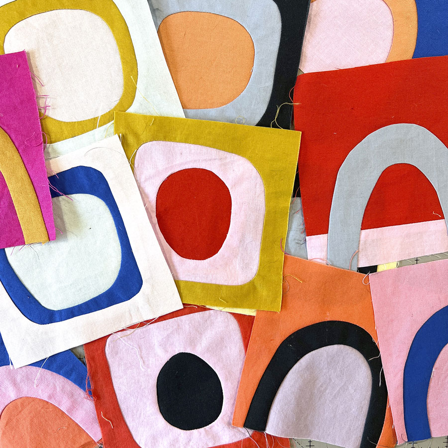 Small quilt blocks of wonky circle and rainbow shapes in bright cheerful colors.