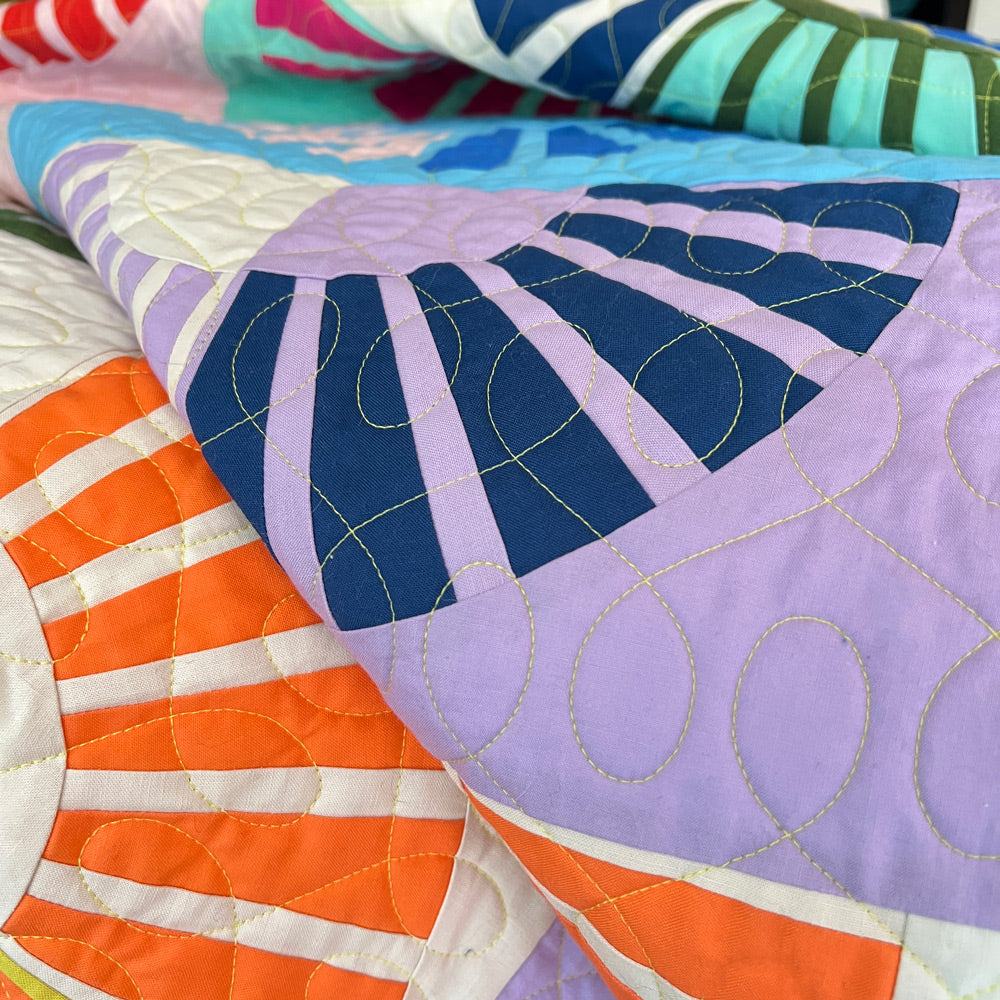 Close up of Sunny quilt blocks showing quilting stitches in yellow thread