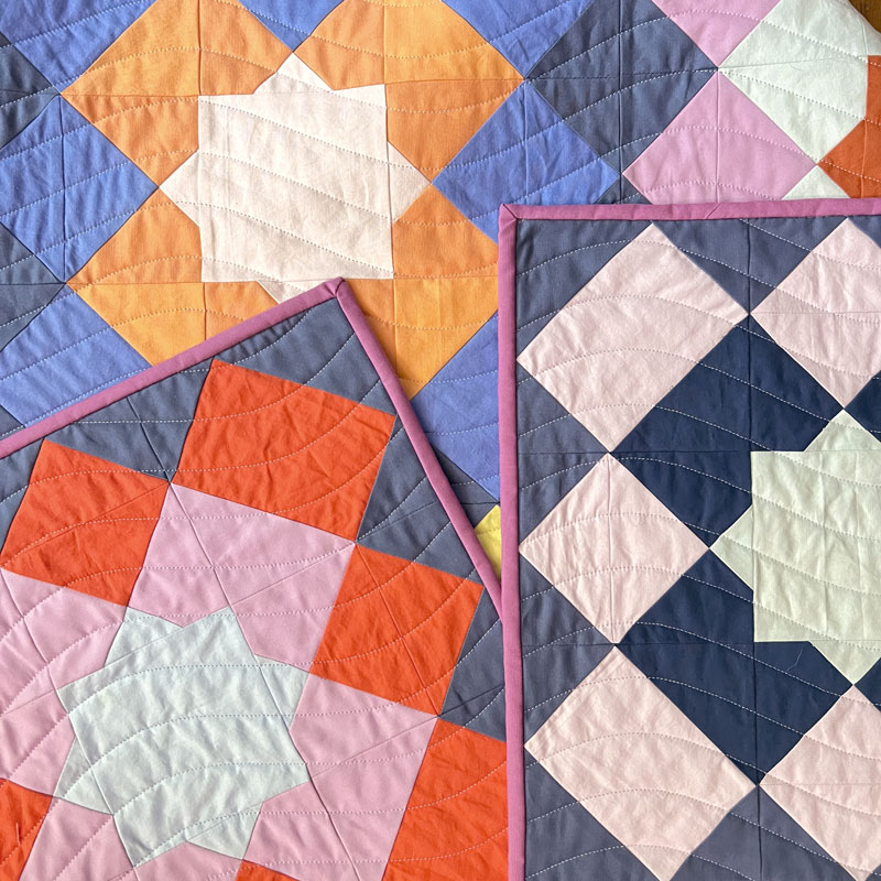 close up of marrakesh quilt showing wavy quilting lines. the quilt is multi colored with a dark blue background