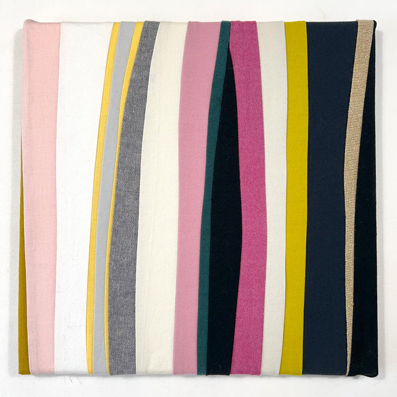 small quilted wall art composed of thick and thin lines in white, pink, black and yellow.