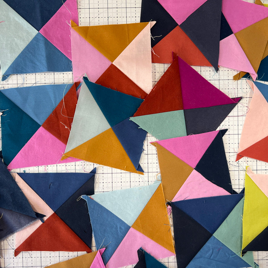 Colorful geometric quilt pattern on a grid background