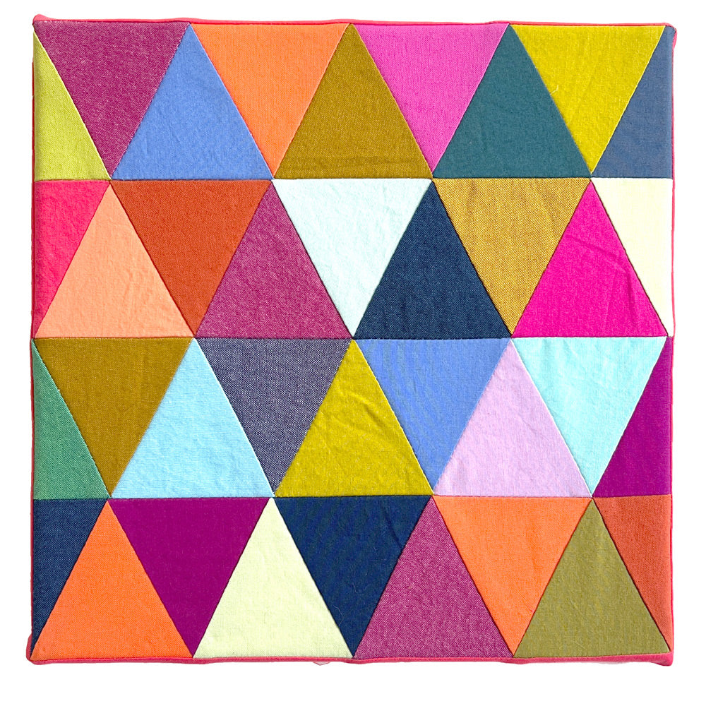 Small quilt block in bright colors, made up of rows of triangles