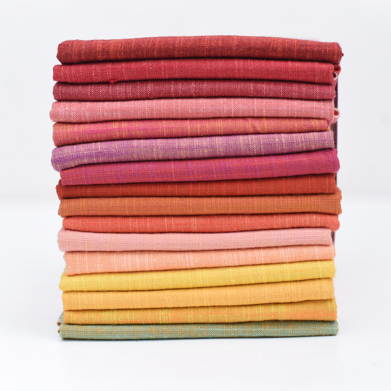 Stack of colorful fabric swatches in various shades on a white background