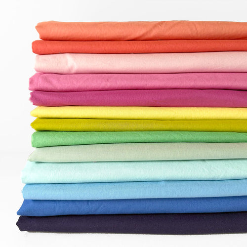 Stack of colorful folded fabrics on a white background