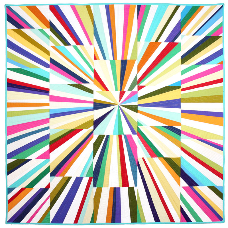 A square quilt featuring a vibrant radial burst pattern with multicolored striped sections radiating from the center, finished with a light blue border.