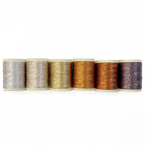 A collection of six spools of hand quilting thread in various metallic shades, arranged side by side.