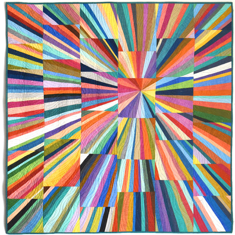 A square quilt with a vivid radial geometric pattern made of many brightly colored striped and block sections radiating from the center, shown flat against a plain white background.