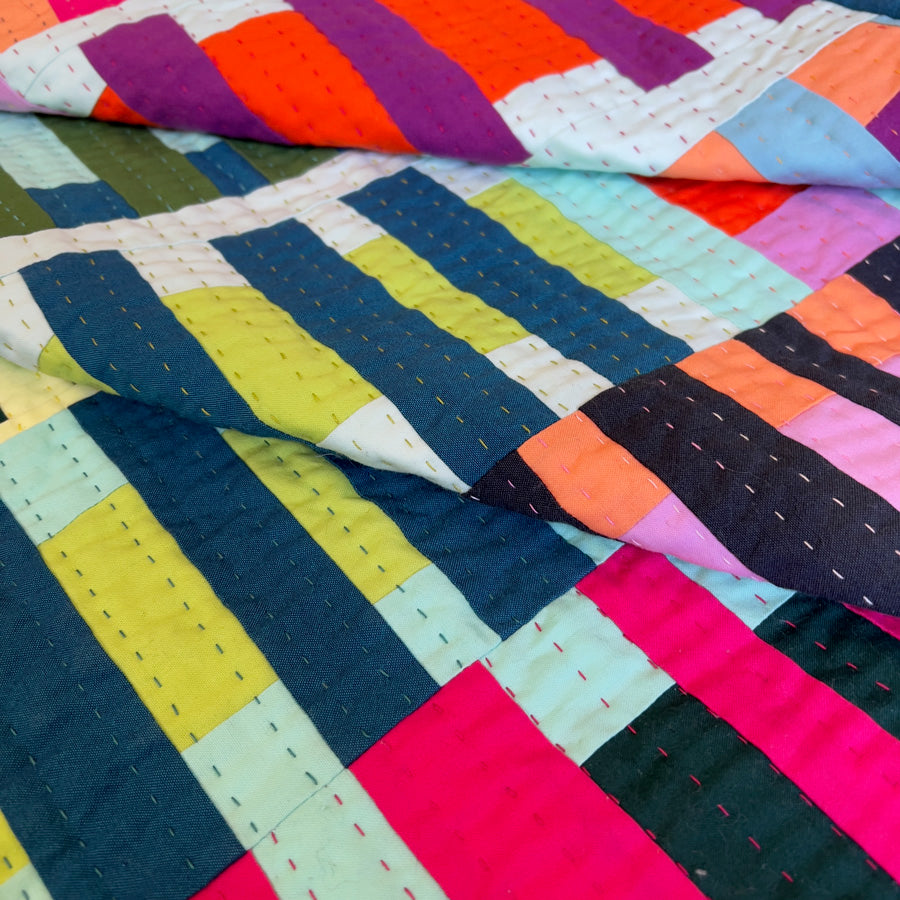 Colorful quilt with geometric pattern on a flat surface