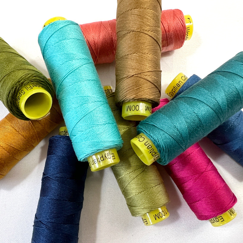 Assorted colorful spools of thread on a white background