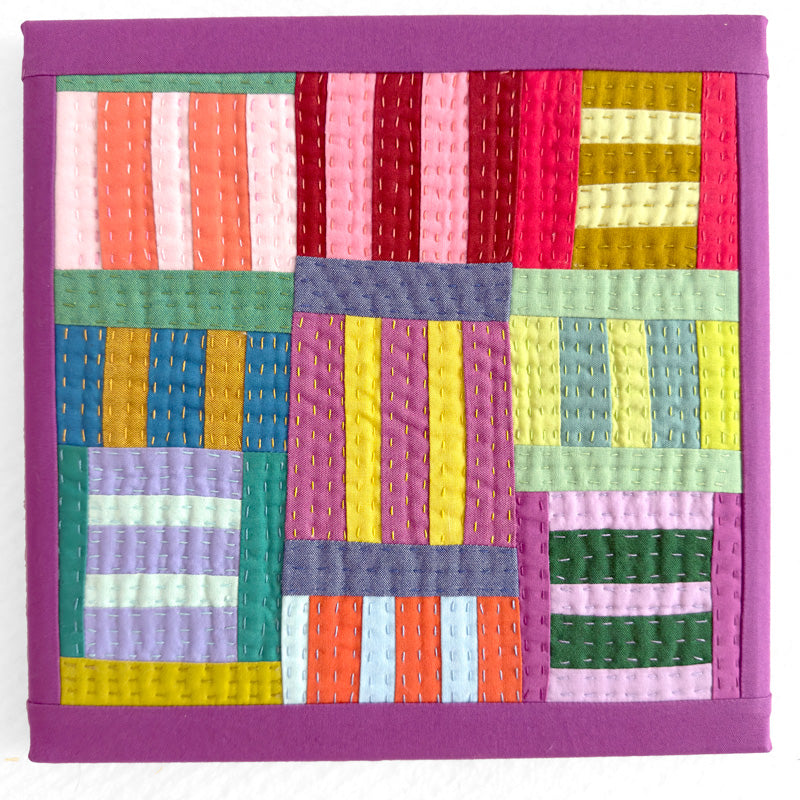 Colorful quilt with a geometric pattern on a white background