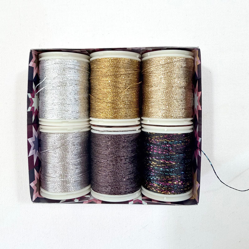 Box of metallic spools of thread on a white background