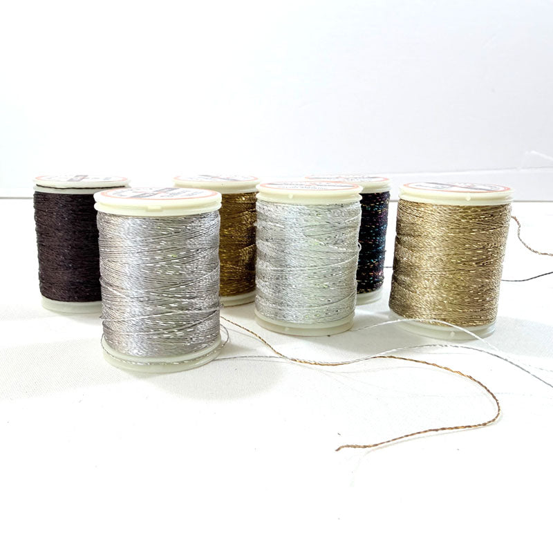 Set of spools of thread in various colors on a white background