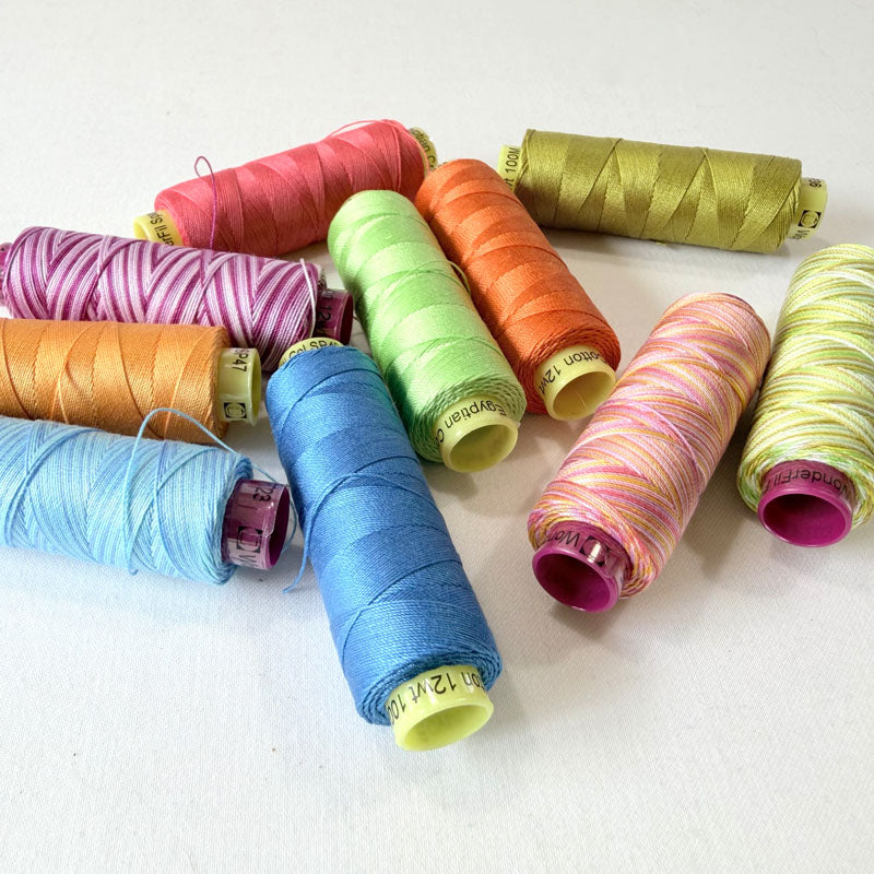 Assorted colorful spools of thread on a white background