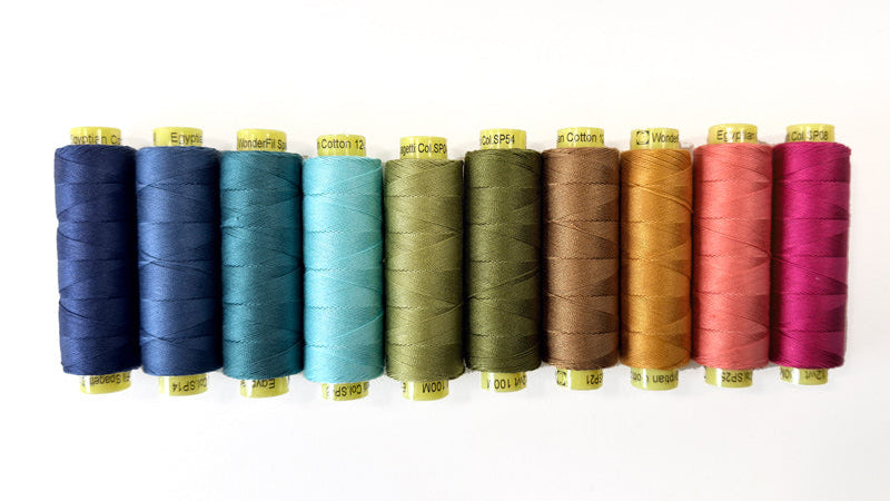 Set of colorful spools of thread on a white background