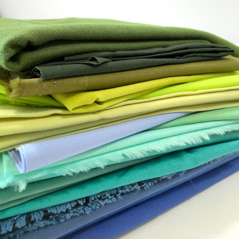 Collection of colorful fabric pieces shapes of blue and green arranged together