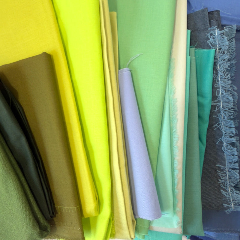 Collection of colorful fabric pieces shapes of blue and green arranged together
