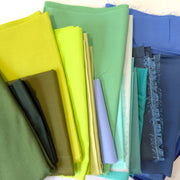 Collection of colorful fabric pieces shapes of blue and green arranged together