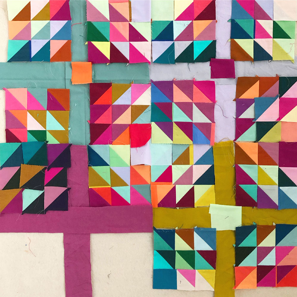 Colorful quilt made of half square triangle blocks with multi colored sashing.
