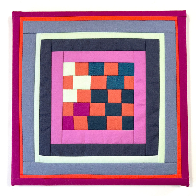 Close-up of handmade art with colorful stitches and geometric forms, perfect for brightening home decor.