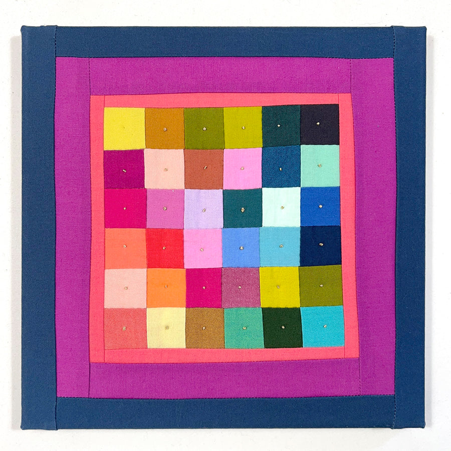 A small quilted study of squares with metallic gold embroidery stitches