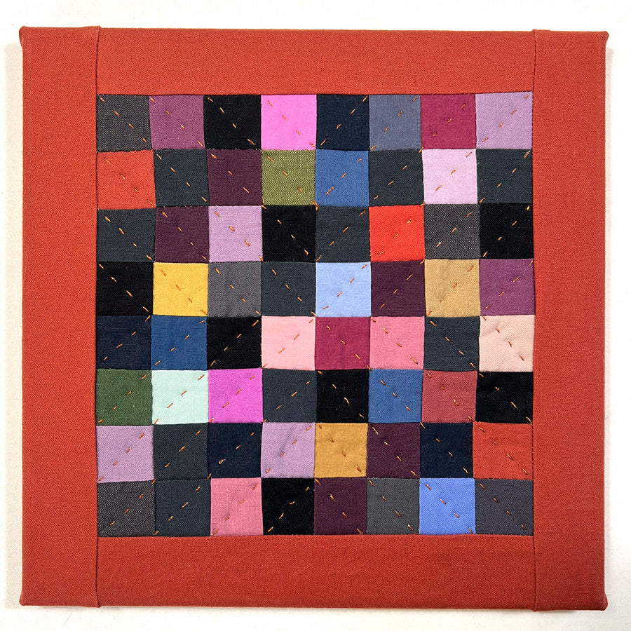  A small quilted wall art composed of multiple dark color squares that is hand pieced, hand quilted and stretched on archival acid free canvas.