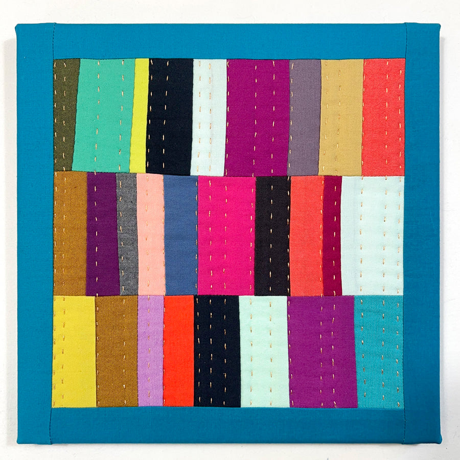  A small quilted wall art composed of multiple bright color rectangles that is hand pieced, hand quilted and stretched on archival acid free canvas.