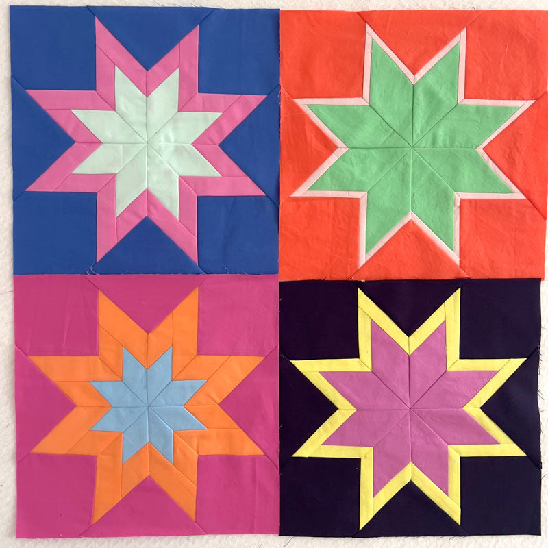 Quilt block with star patterns in various colors on a white background
