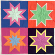 Quilt with star blocks in various colors on a white background