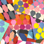 Colorful geometric quilt with variously shaped patches on a white background