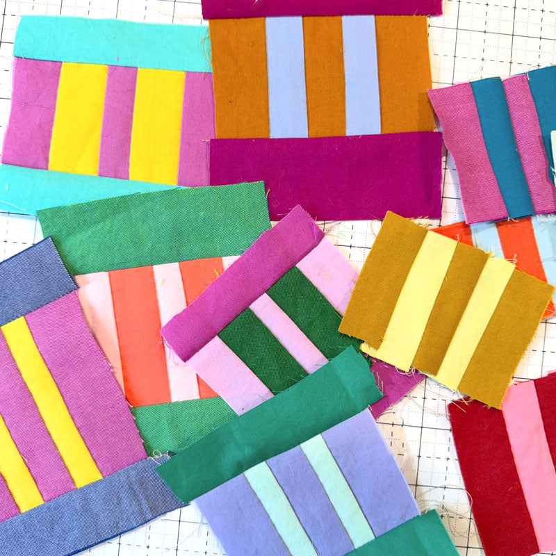 Colorful striped fabric squares on a grid background