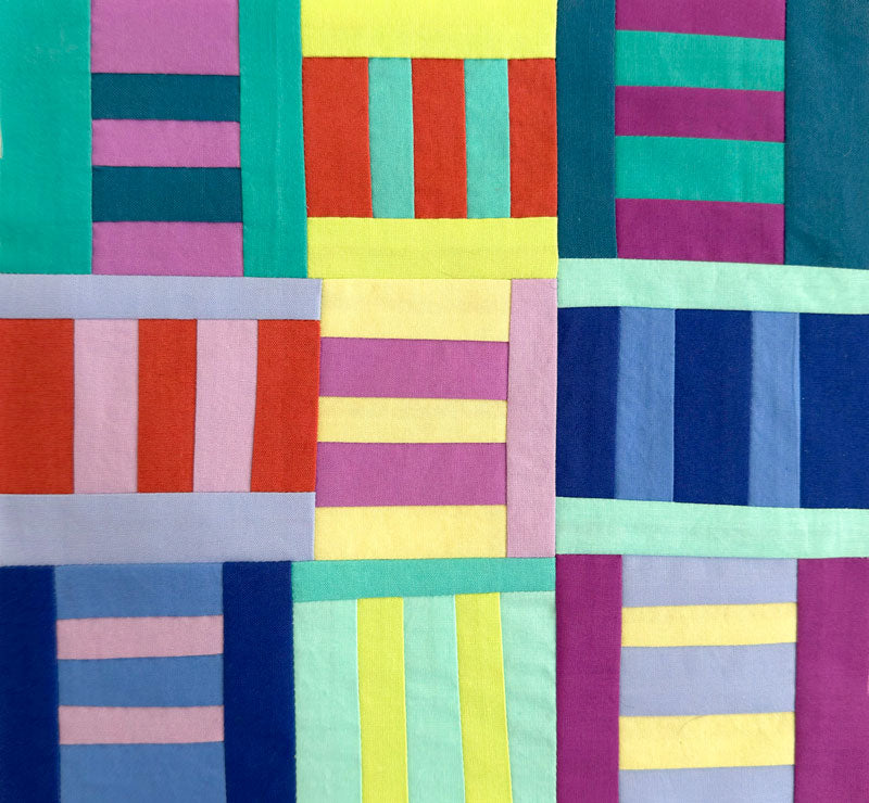 Colorful quilt with geometric pattern of horizontal and vertical stripes.