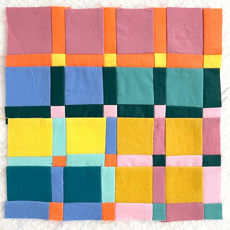 Colorful patchwork quilt with square patterns on a white background