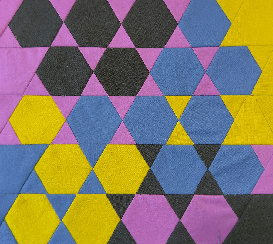Hexagonal patchwork pattern with purple, blue, yellow, and black colors.