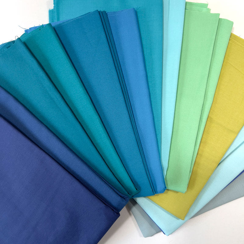 Set of colorful cool color fabric swatches arranged in a fan-like pattern.