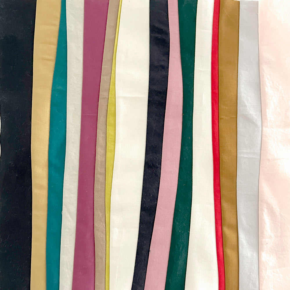 Sewn lines of various widths in pinks, grays, whites and yellows.