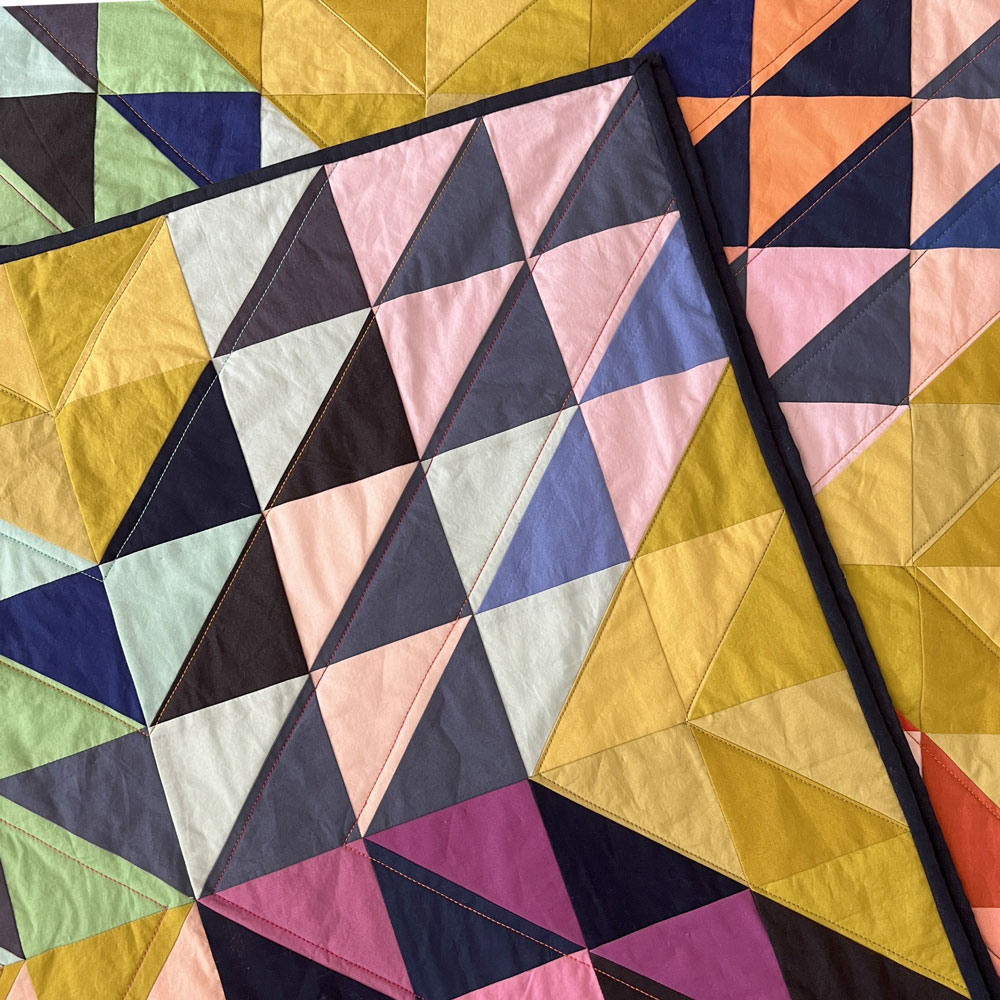 close up of quilt showing hand quilting and binding