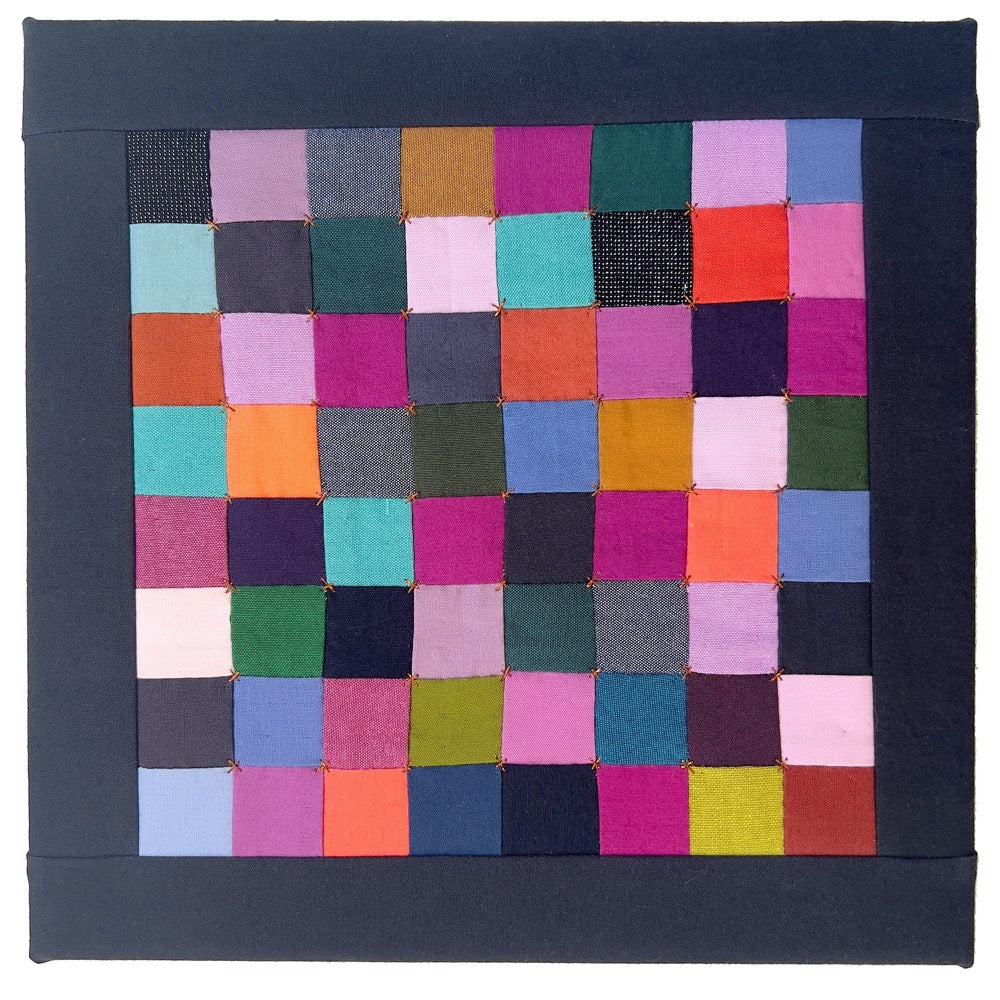 Small hand sewn quilt of bright colored squares, finished with embroidery in bronze thread.