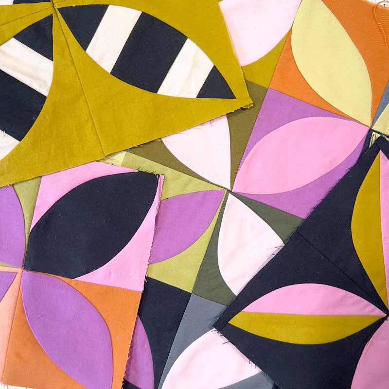 A pile of small quilt studies made of ruler free orange peel blocks.