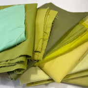 Stack of green fabric swatches on a white background