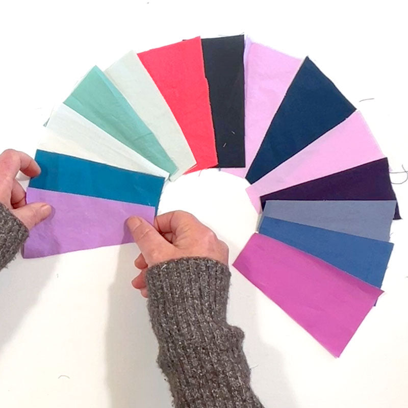 A wonky circle on a design board . The circle is composed of wedges in multiple bright colors.