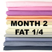 Stack of colorful fabric with 'Month 2 Fat 1/4' text on a white background