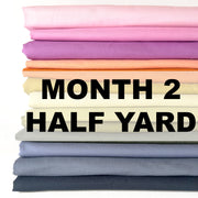 Stack of colorful fabric with 'Month 2 Half Yard' text on a white background