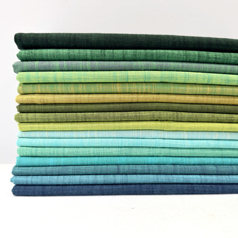 Stack of green and blue fabric swatches on a white background