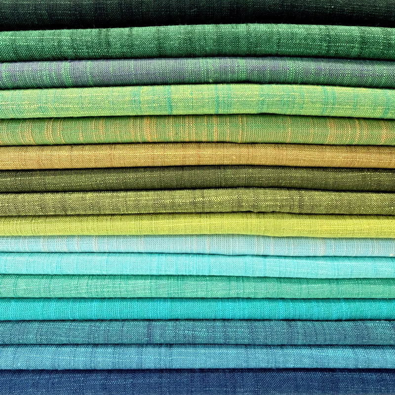 Stack of green and blue fabric swatches arranged in a gradient.
