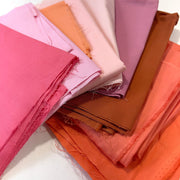 Stack of colorful fabric swatches in various shades.