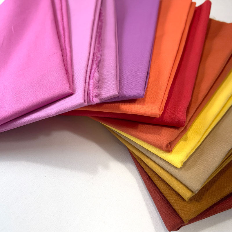 Stack of colorful fabric swatches on a white background