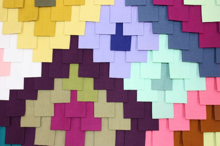 close up of textured quilt made of colorful folded fabrics